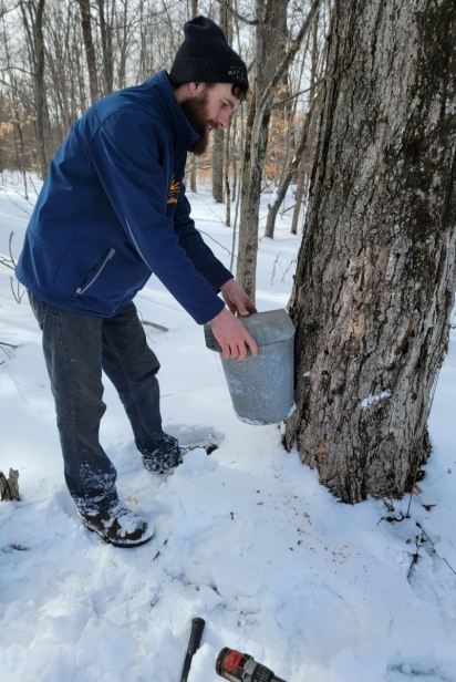 Farmer Kelby Snyder taps a maple tree