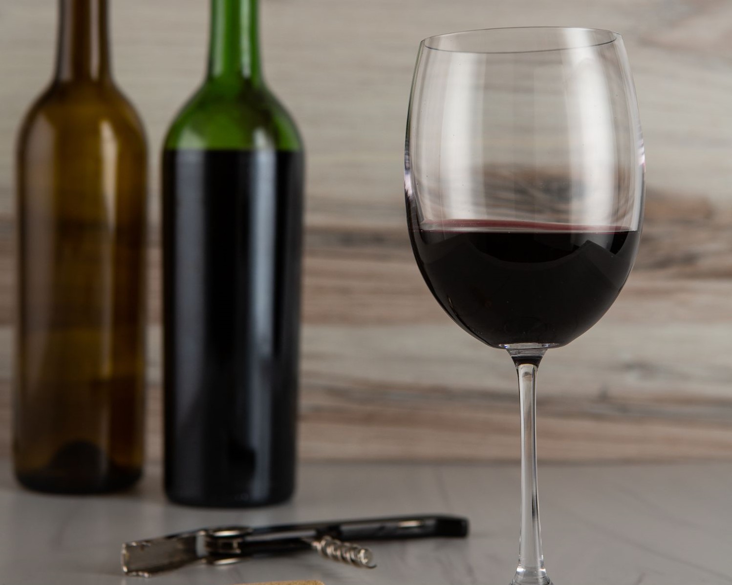 Glass and bottles of homemade wine