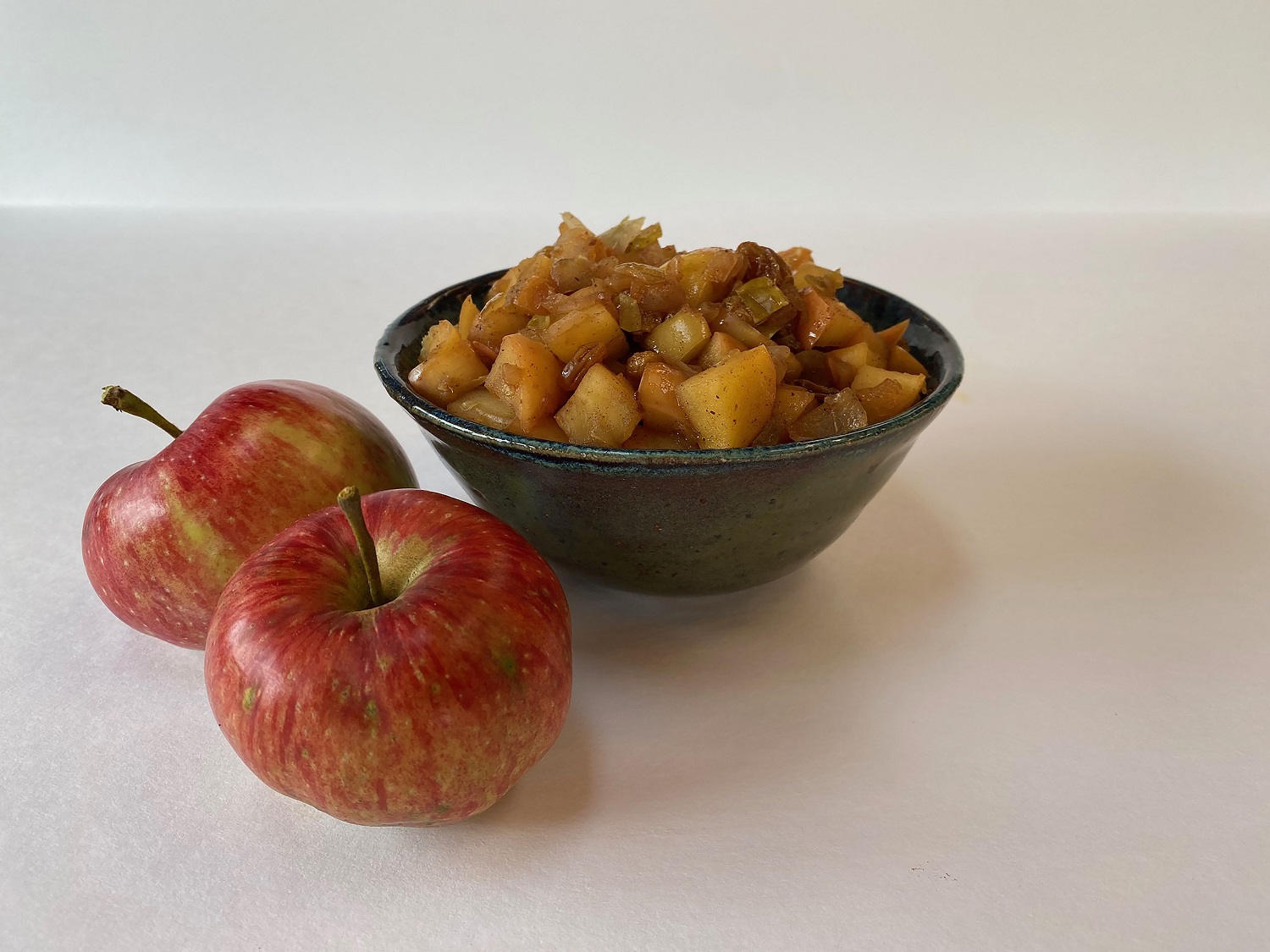 Bowl of spicy apple chutney and apples