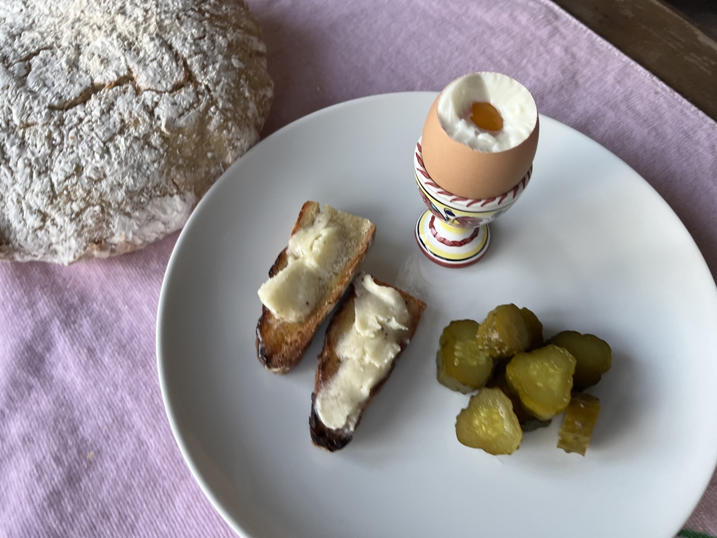 Egg in a cup with whipped truffle butter toast points and bread and butter pickles